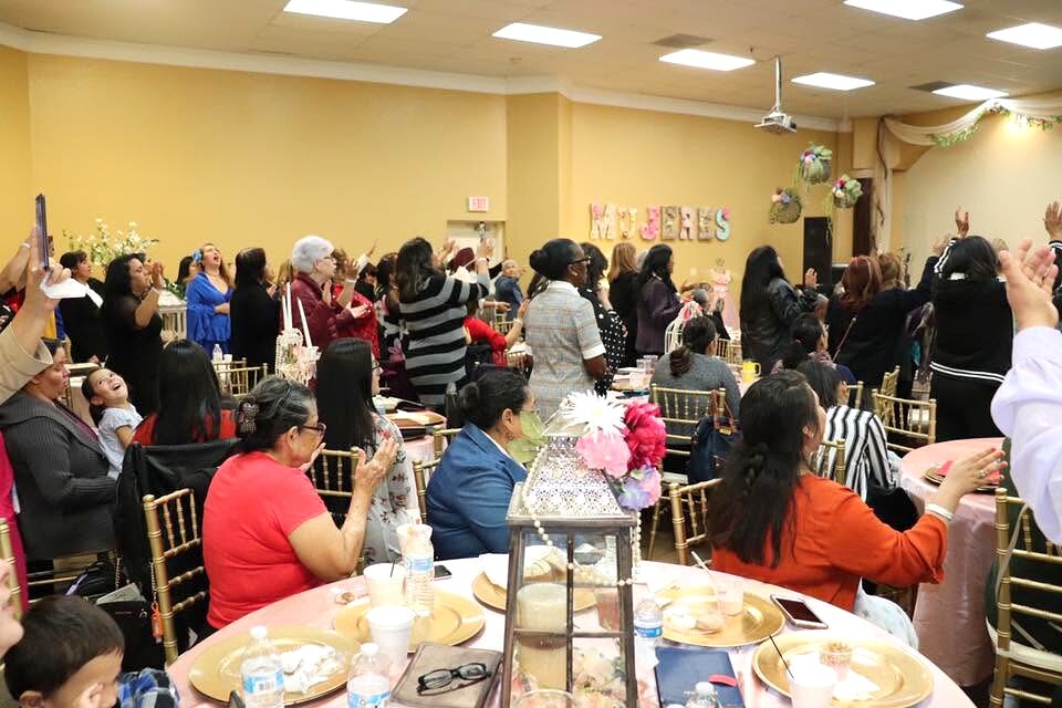Mujeres del ministerio femenil reunidas en oración